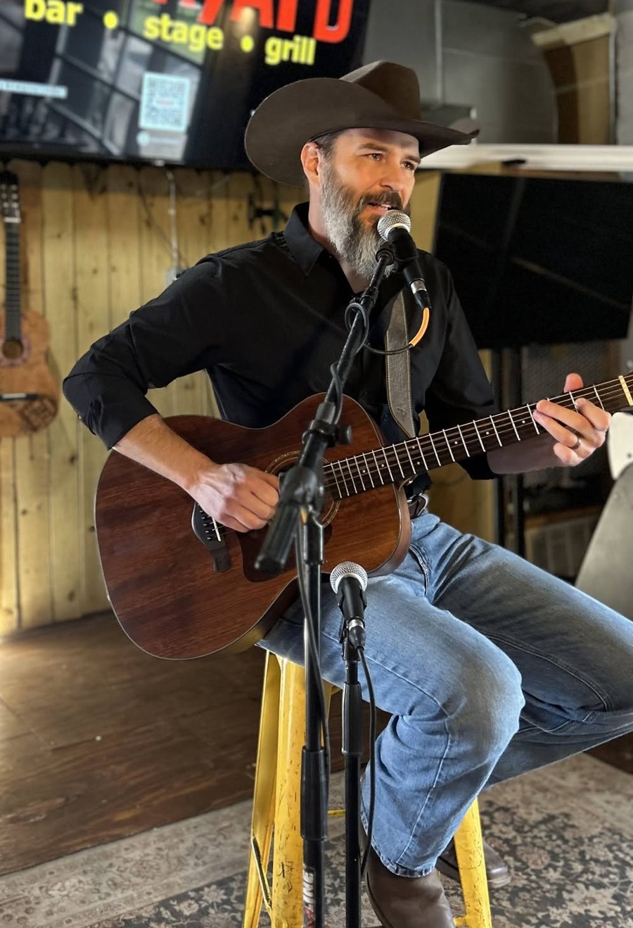 Glen Meloy performing live with an acoustic guitar.